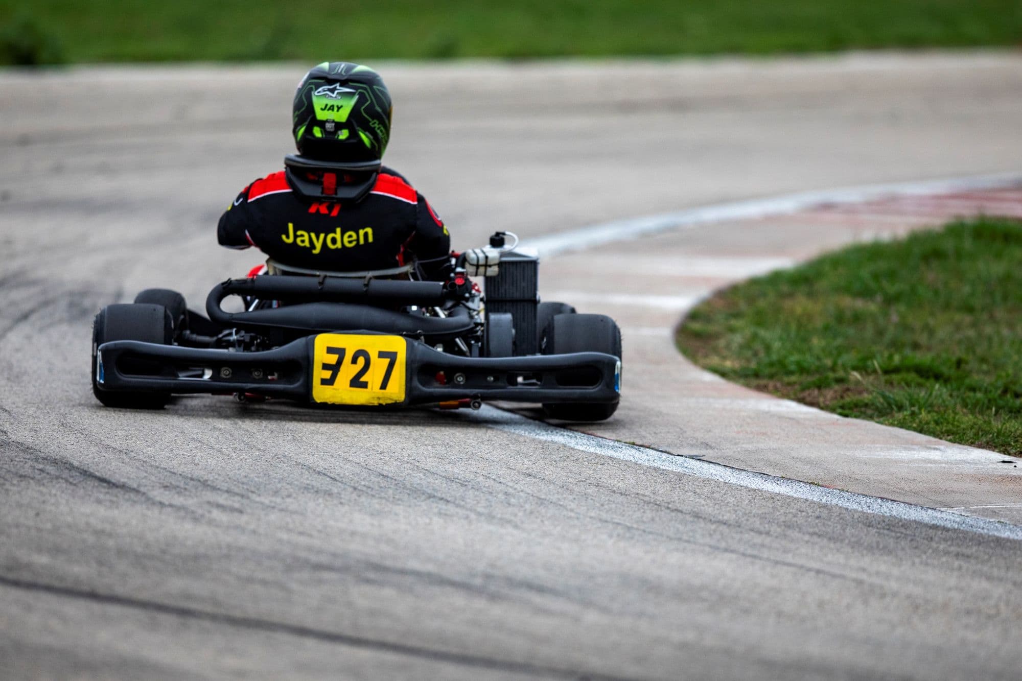 A kart with a yellow number plate rides the curb head-on at KartMoto.