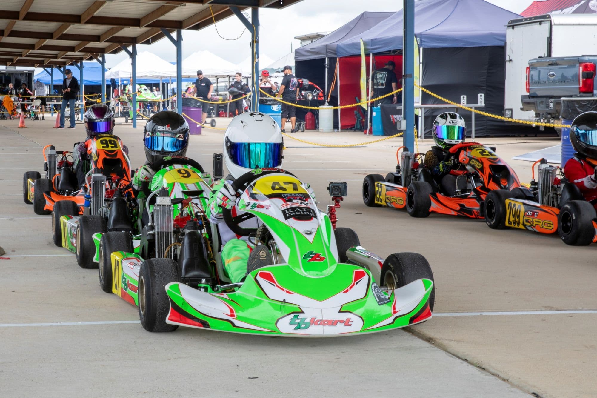 A green kart leading a group through the hot pit at KartMoto.