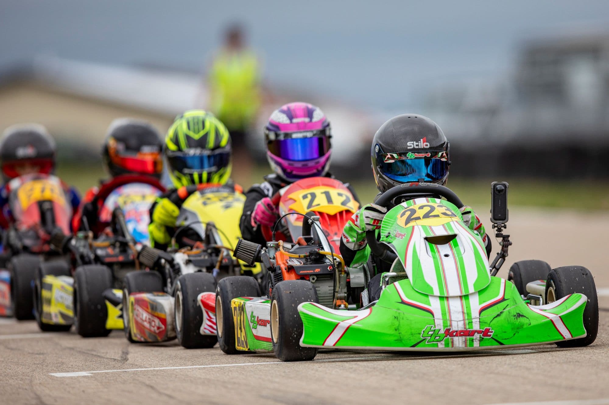 The front row of a junior grid at KartMoto, shot tight from trackside.